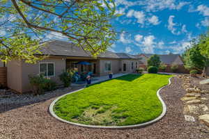 Back of house with a fenced backyard, stucco siding, a patio area, and a tile roof
