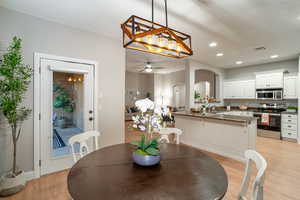 Dining room featuring light wood-type flooring, recessed lighting, a chandelier, and ceiling fan