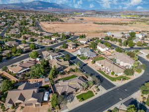 Aerial view of property and surrounding area with a mountainous background and nearby suburban area
