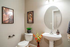 Half bathroom featuring a textured wall and toilet