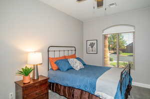 Carpeted bedroom featuring ceiling fan and baseboards