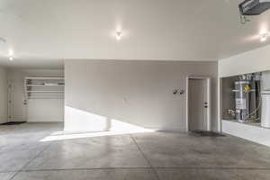 Garage featuring strapped water heater and a garage door opener