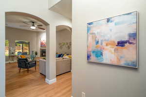 Corridor with light wood-style flooring, arched walkways, and a textured wall