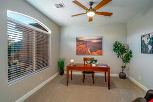 Home office featuring light carpet and a ceiling fan