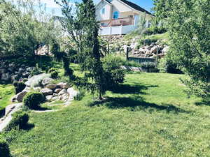 View of grassy yard with a balcony