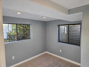 Carpeted empty room featuring recessed lighting