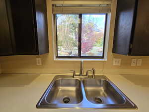 Kitchen view of dark brown cabinetry and light countertops