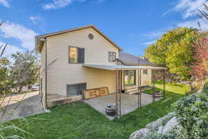 Rear view of house with a yard, a patio area, and entry steps