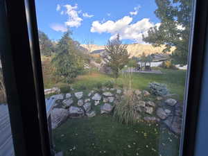 View of grassy yard featuring a garden pond and a mountain view