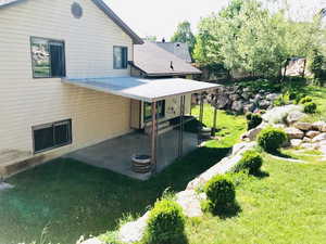 Back of house with a yard, a patio area, and a fire pit