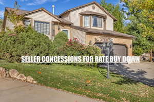 Traditional home with brick siding, driveway, a garage, and a front yard