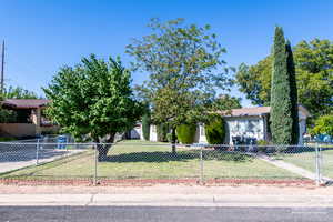 View of property hidden behind natural elements featuring a fenced front yard