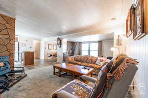 Living area featuring wood finished floors, ornamental molding, and a textured ceiling