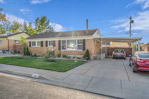 Ranch-style house with brick siding, driveway, and a carport