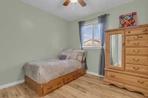 Bedroom with light wood-type flooring and a ceiling fan