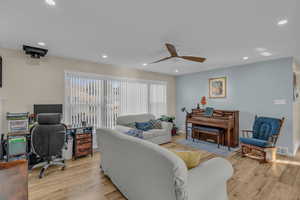 Living room featuring a desk, recessed lighting, light wood-style flooring, and a ceiling fan