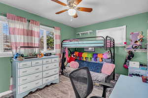 Carpeted bedroom featuring a ceiling fan and baseboards