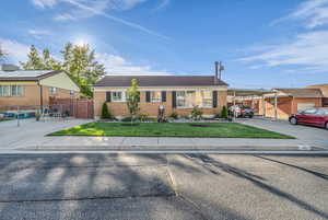 Single story home with brick siding, an attached carport, and driveway