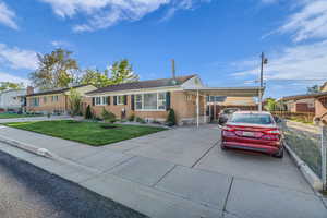 Ranch-style house featuring brick siding, a carport, and concrete driveway