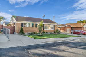 Single story home with brick siding, a front yard, and a shingled roof