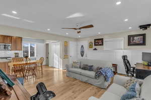 Living area featuring light wood-style floors, recessed lighting, and a ceiling fan