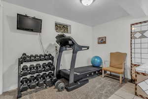 Workout area with a textured ceiling and light tile patterned floors