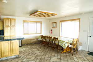 Dining room featuring brick patterned flooring and baseboards