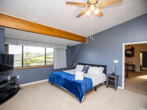 Carpeted bedroom with a ceiling fan and a mountain view