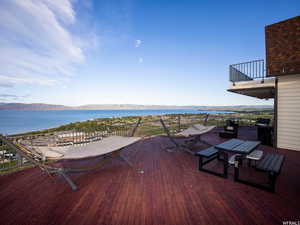 Wooden deck with a water and mountain view and outdoor dining space