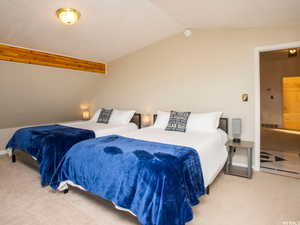 Bedroom featuring carpet and vaulted ceiling