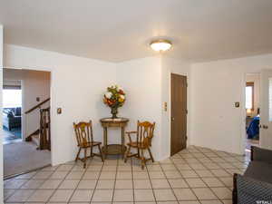 Living area featuring healthy amount of natural light, stairs, and light tile patterned flooring
