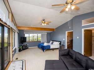 Bedroom featuring carpet floors, a textured ceiling, a ceiling fan, and attic access