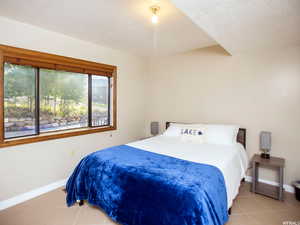 Bedroom with light tile patterned floors and baseboards