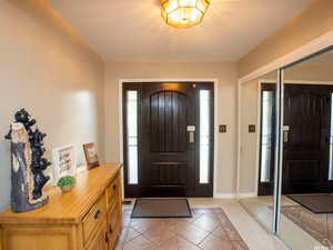 Entryway with light tile patterned flooring and baseboards