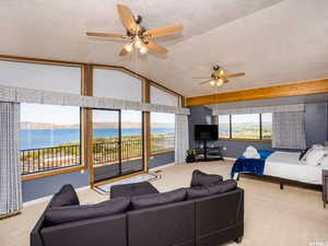 Carpeted living room with a textured ceiling and ceiling fan
