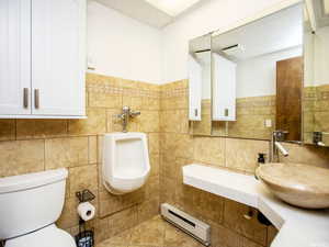 Bathroom with baseboard heating and tile walls