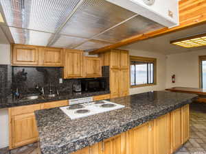 Kitchen with ventilation hood, brick floors, white appliances, decorative backsplash, and a center island