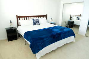 Bedroom featuring light carpet and a closet