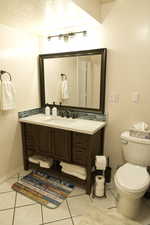 Bathroom featuring light tile patterned floors, vanity, a textured ceiling, and tasteful backsplash