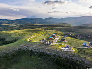 Aerial view of property and surrounding area featuring rural landscape and a mountain backdrop