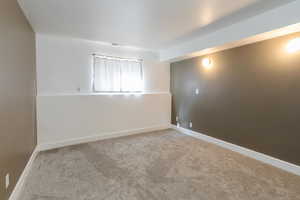 Unfurnished room with light carpet and baseboards