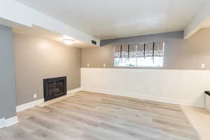 Basement featuring a fireplace and light wood-style floors