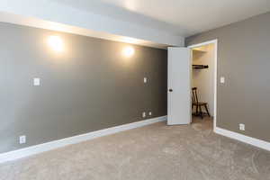 Unfurnished bedroom featuring light colored carpet and baseboards