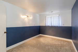 Carpeted empty room featuring baseboards