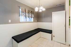Unfurnished dining area featuring light tile patterned floors and a chandelier