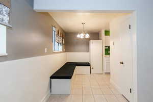 Hall with a chandelier and light tile patterned flooring