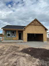 Unfinished property with roof with shingles, covered porch, a garage, and driveway