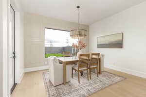Dining area featuring light wood-type flooring and a chandelier