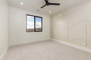 Spare room featuring light colored carpet, ceiling fan, and recessed lighting