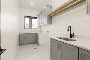 Laundry room with cabinet space, hookup for a washing machine, light tile patterned floors, and recessed lighting